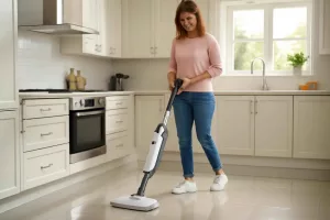 Cordless steam mop cleaning shiny tile floor in a modern kitchen