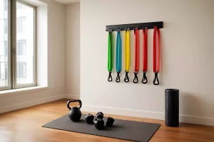 Colorful resistance bands hanging on a wall rack in a home gym