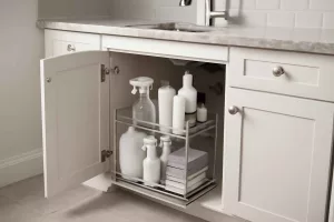 Under-sink pull-out cabinet organizer with shelves holding cleaning supplies