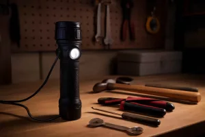 Rechargeable flashlight on a garage workbench for home repairs and emergency use
